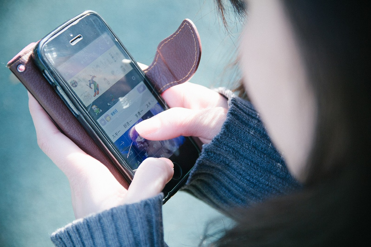 スマホを操作する女性 Wikimedia